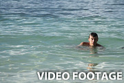The man swims in the tropical sea
