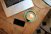 Cup of coffee on table with phone