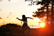 silhouette of young woman dancing in sunset