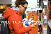 young woman in the store choosing and buying products