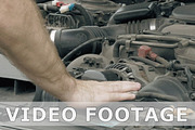 Auto mechanic visually examines car motor engine