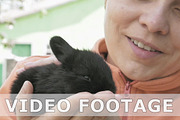 Girl holds and pets little baby black rabbit
