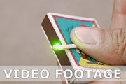 Guy is lighting matchstick with a green laser beam