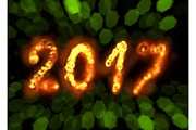 Happy new year 2017 isolated numbers written with flame fire sparkle light on black blurred bokeh background frame