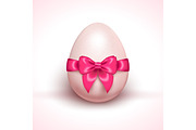 Egg with pink ribbon bow isolated on white