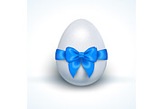 Egg with blue ribbon bow isolated on white