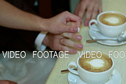 Hands of bride and groom holding a cup of coffee