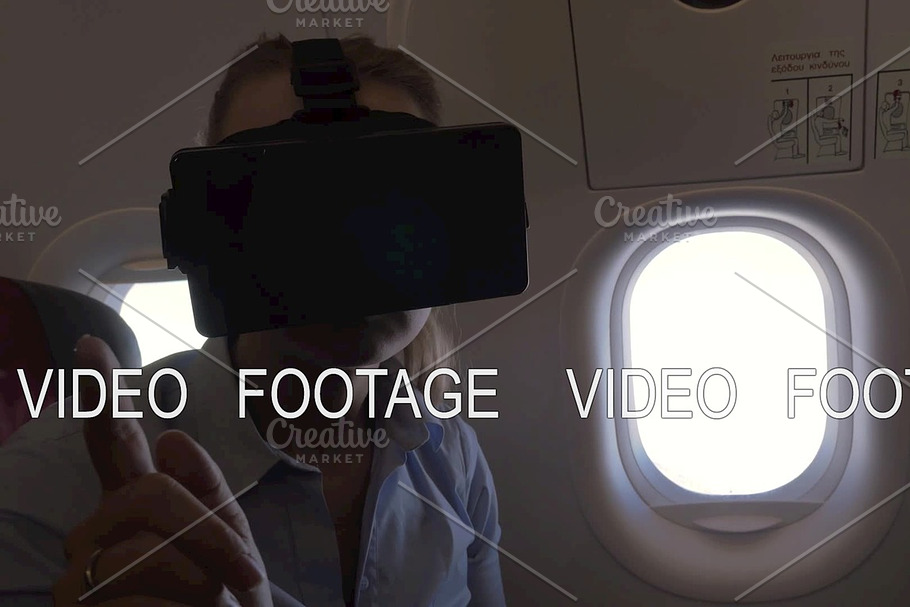 View of woman using VR-helmet for smartphone in airplane
