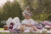 Happy child sits on a meadow around Easter decoration