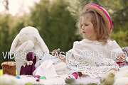 Happy child sits on a meadow around Easter decoration