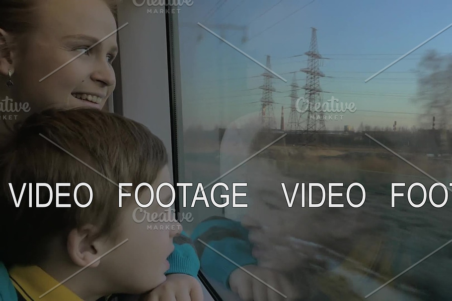 Small boy with mother sitting against window in their rail train place and watching outside in Graphics - product preview 8