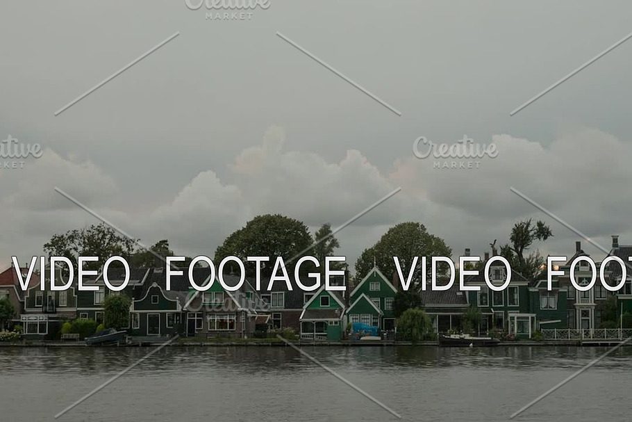 Timelapse of clouds over houses on river bank, Netherlands