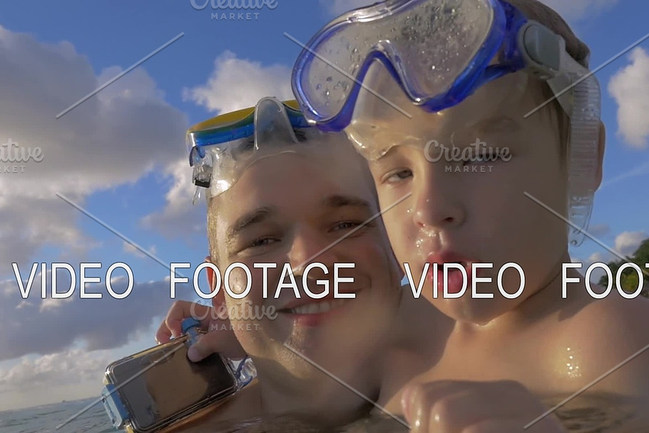 Slow motion view of happy young father with son in the water in snorkeling masks, Port Louis, Mauritius Island