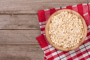 Oat flakes in a wooden bowl on old wooden background with copy space for your text. Top view