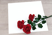 Red roses with paper on the table