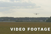 Small airplane lands on the grass field - slowmotion 60 fps