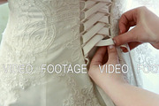 helps lace up the bride dress