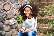 Beautiful african american girl with smart phone and earphones.