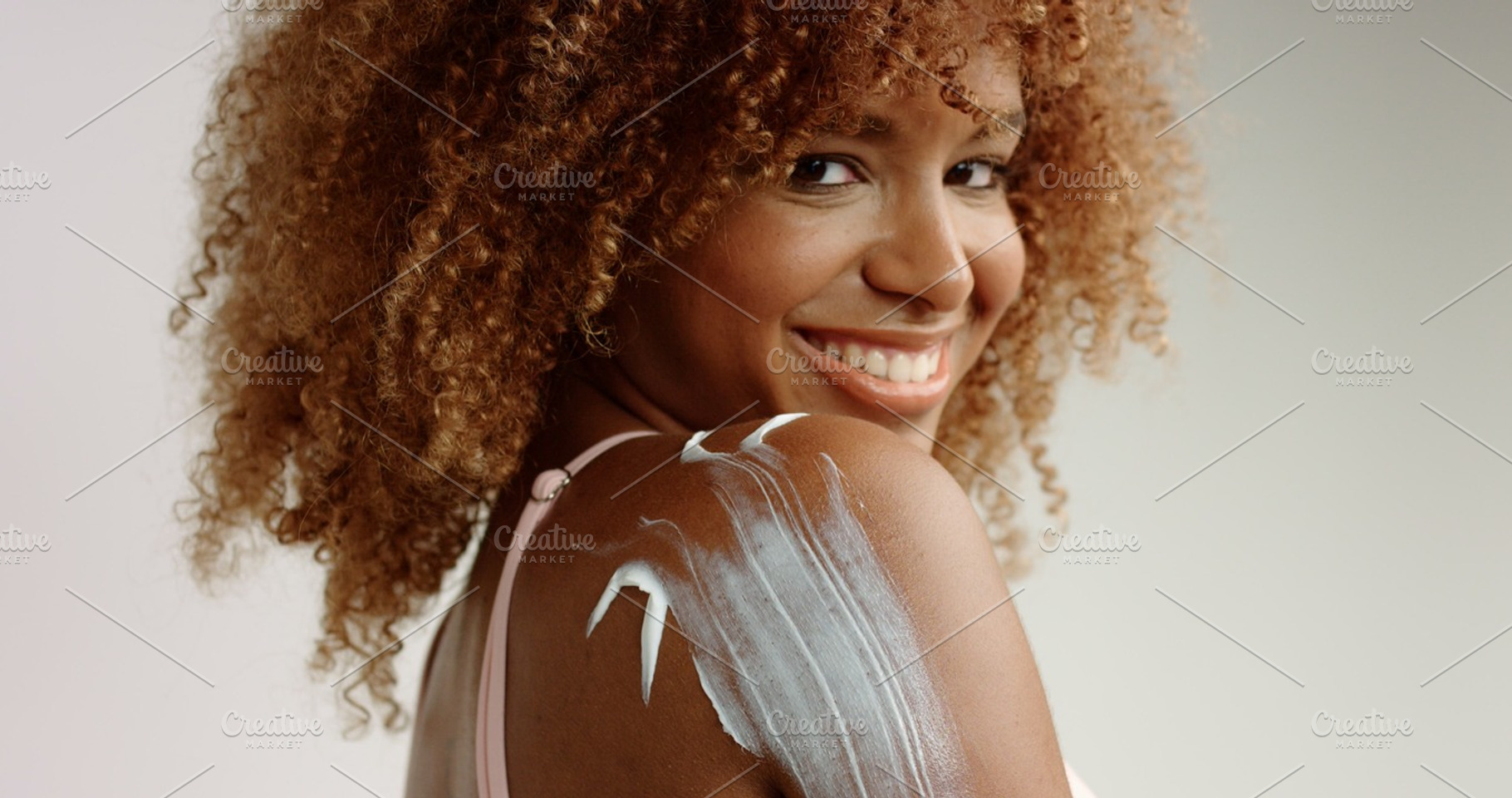 Mixed Race Black Woman With Blonde Curly Hair In Studio With Cream