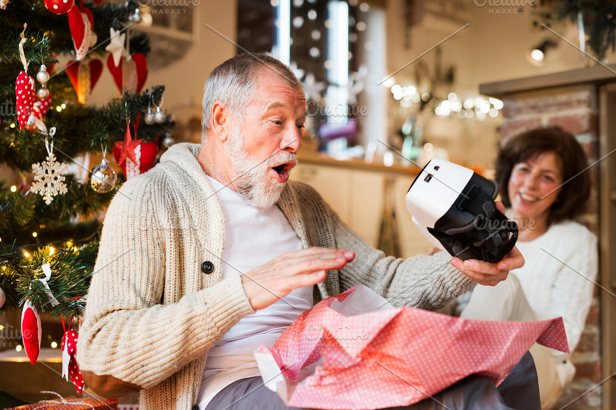 Senior couple in front of Christmas tree with VR goggles. in Graphics - product preview 8