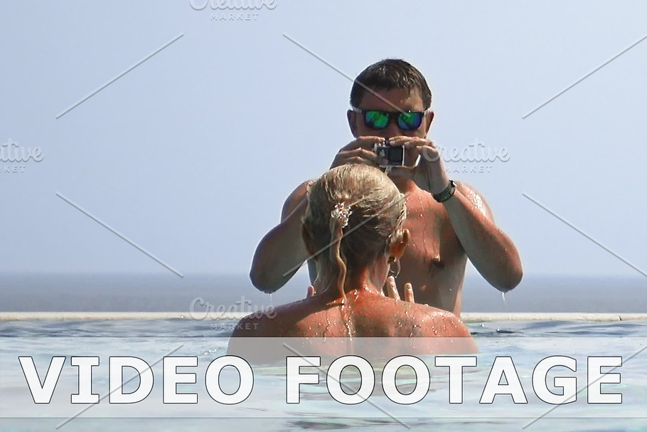 Man and woman shooting a video in a swimming pool