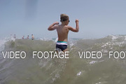 Child bathing in the sea and jumping with wave