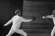 Two fencers man and woman have fencing match indoors
