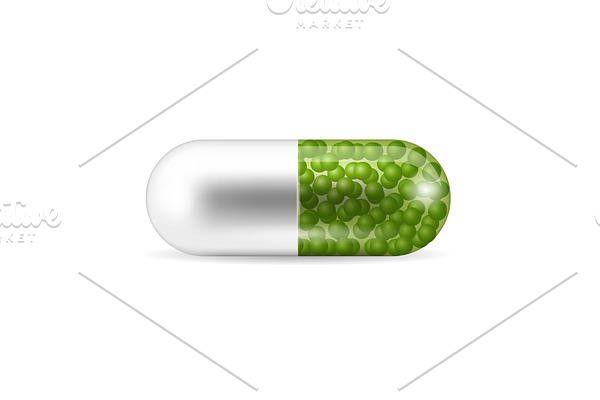 A pill in the capsule shape with the green granules inside it.