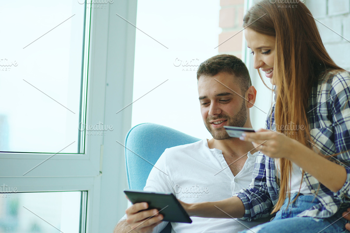 Young cheerful couple using digital tablet computer for online shopping sit on balcony in modern loft apartment in Graphics - product preview 8