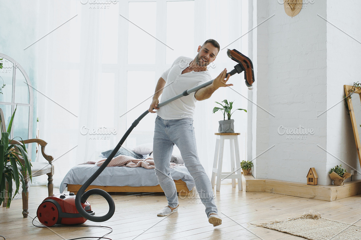 Young man having fun cleaning house with vacuum cleaner dancing in Graphics - product preview 8