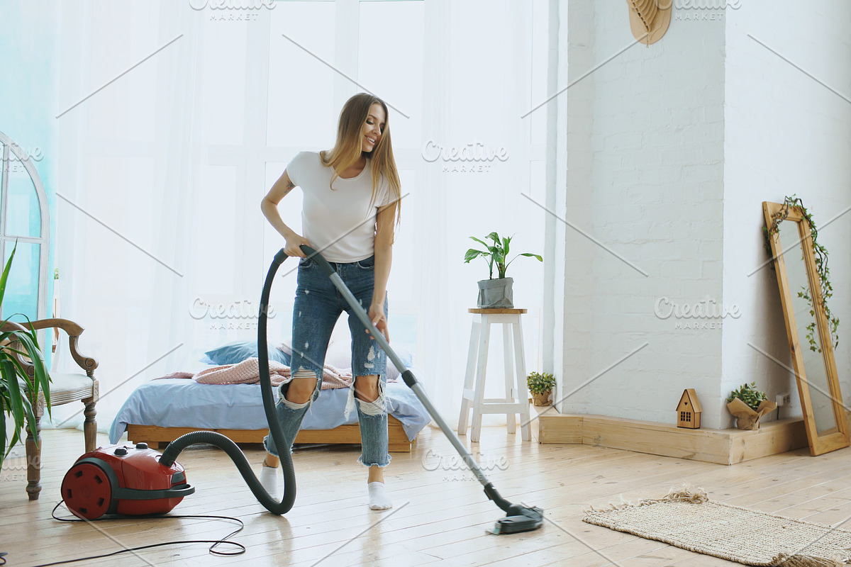 Young woman having fun cleaning house with vacuum cleaner dancing and singing at home in Graphics - product preview 8