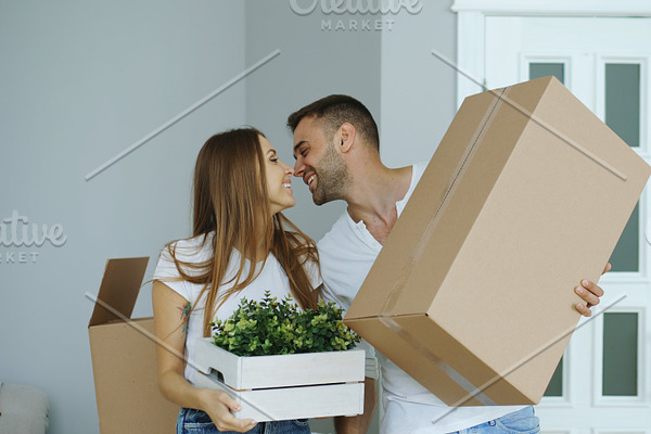 Young happy couple walking into new house after moving day and kiss each other
