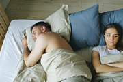 Top view of upset lying sleepless couple in bed offended because of quarrel