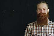 Closeup portrait of hipster man looking at camera and smiling on black background