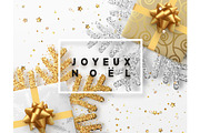 French text Joyeux Noel. Christmas background with gifts box and shining golden and silver snowflakes.