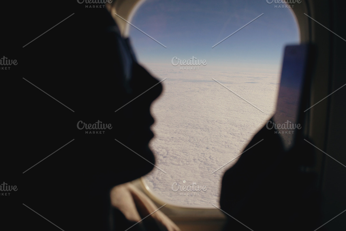 Closeup silhouette woman sitting near airplane window using mobile phone during flight in Graphics - product preview 8
