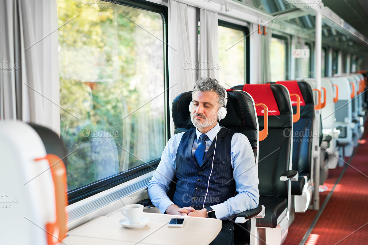 Mature businessman with smartphone travelling by train. in Graphics - product preview 8