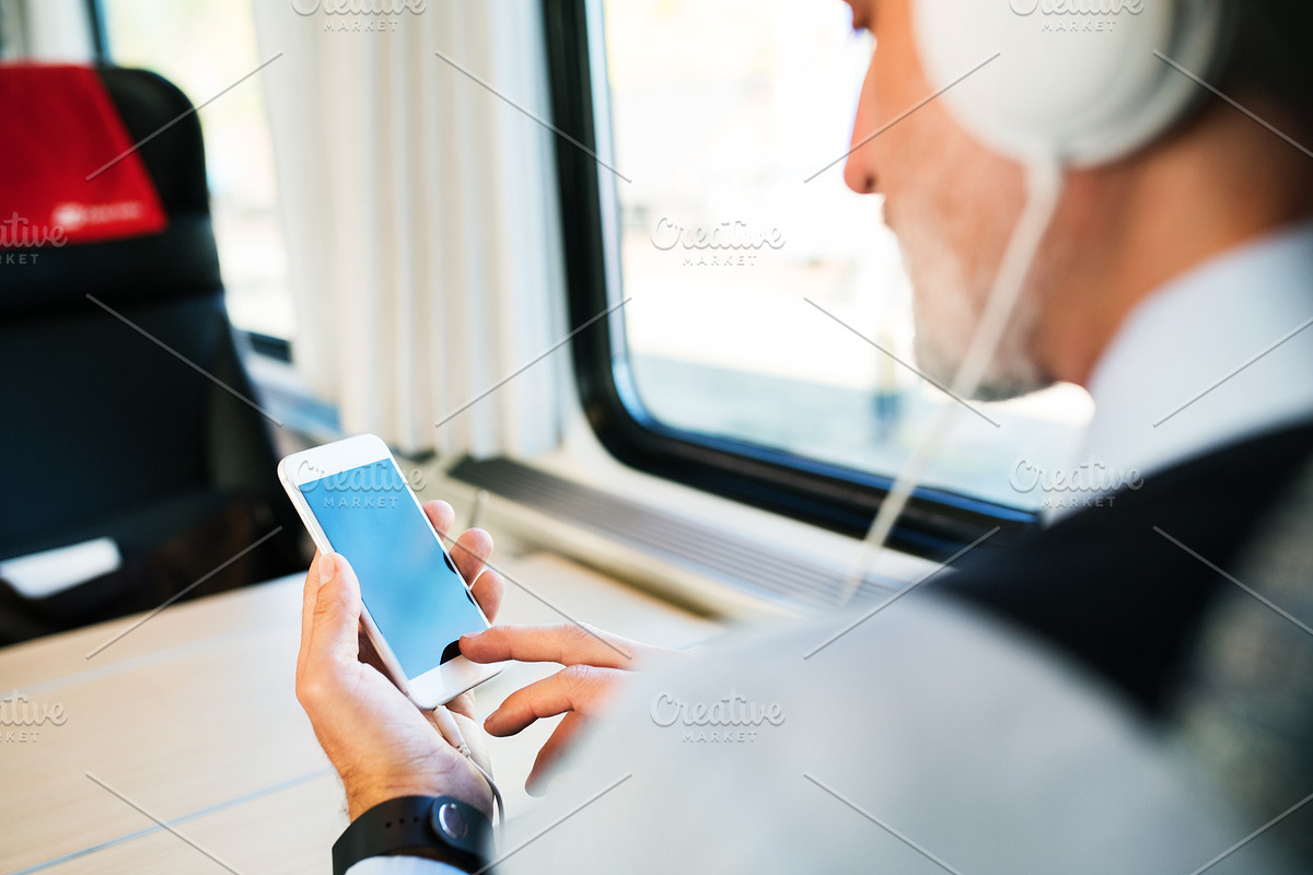 Mature businessman with smartphone travelling by train. in Graphics - product preview 8