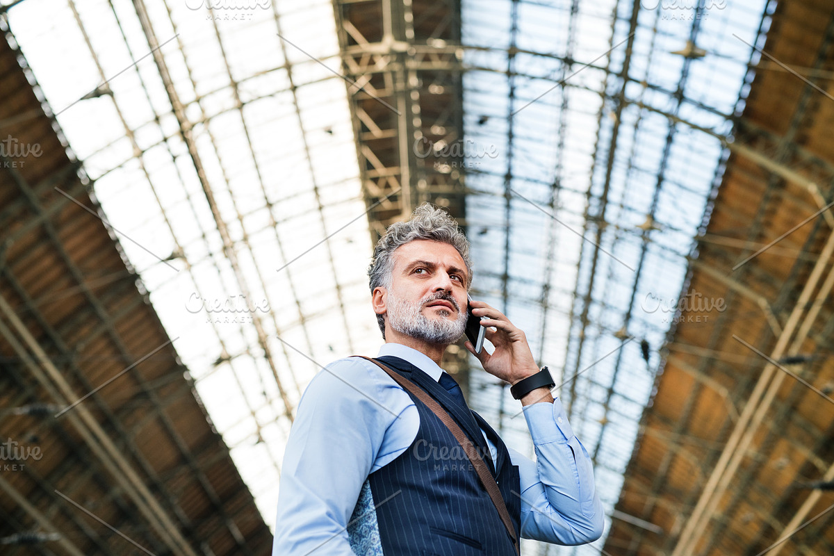 Mature businessman with smartphone on a train station. in Graphics - product preview 8