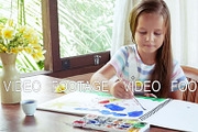 Child artist painting watercolor paints
