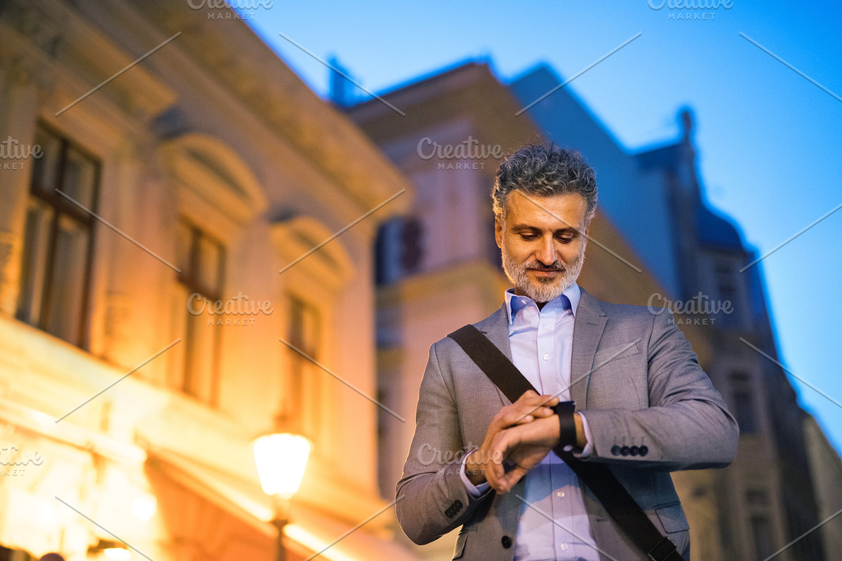 Mature businessman with a smartwatch in a city. in Graphics - product preview 8