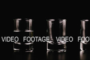 Vodka fills a glass on a black background. Stop motion, animation