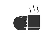 Hand holding cup with hot drink glyph icon