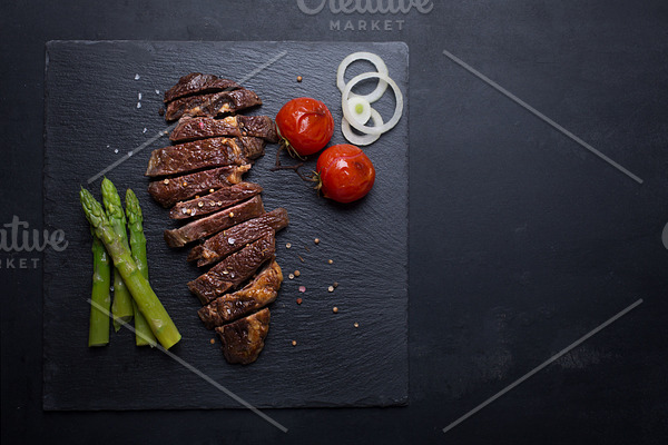 Grilled beef steak on a black background with copy space