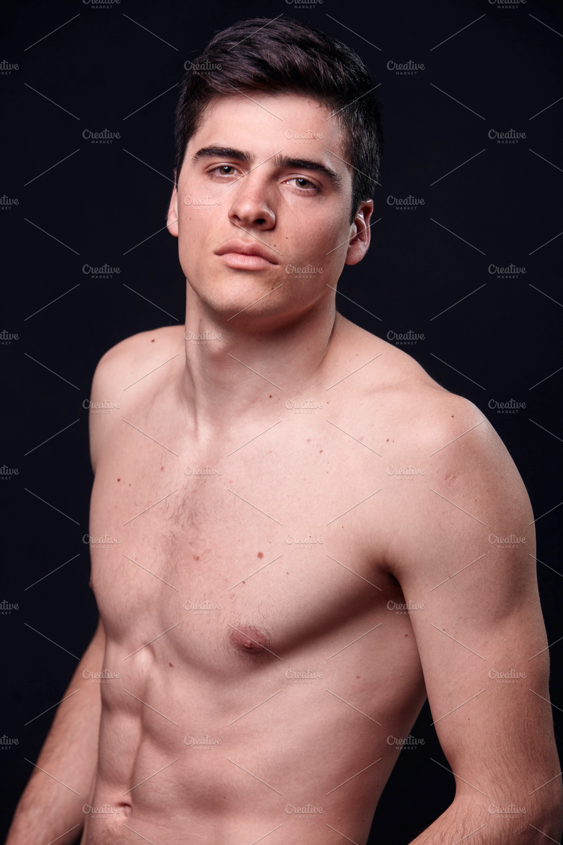 one young handsome man, model shirtless, simple studio upper body shot