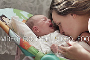 beautiful young mom kiss and soothes cry of newborn baby