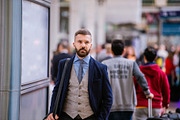 Hipster businessman in blue suit at the station walking