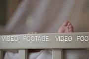 Baby feet outside the crib