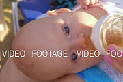Baby lying on mothers lap and drinking from the bottle