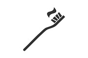 Toothbrush with toothpaste glyph icon